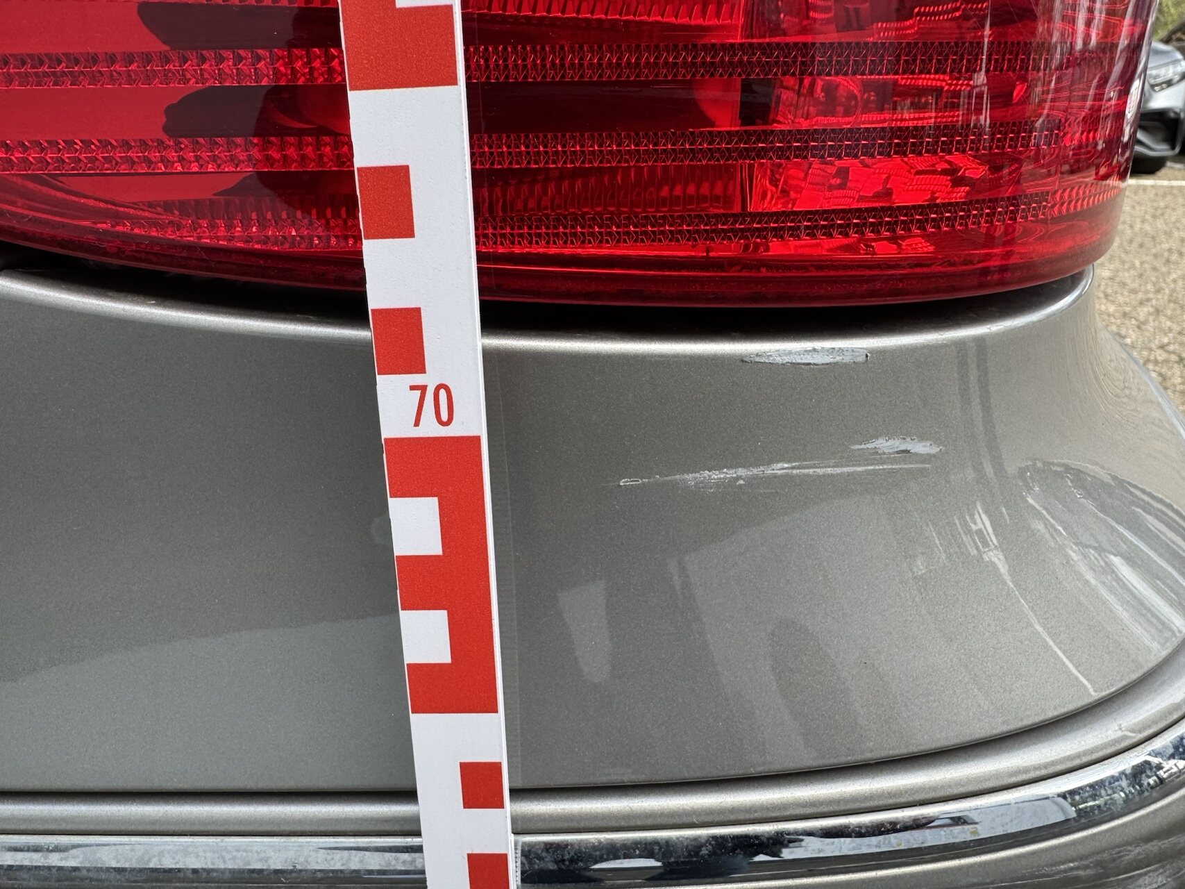 Dokumentation eines Stoßfängerschadens mit einem Messstab