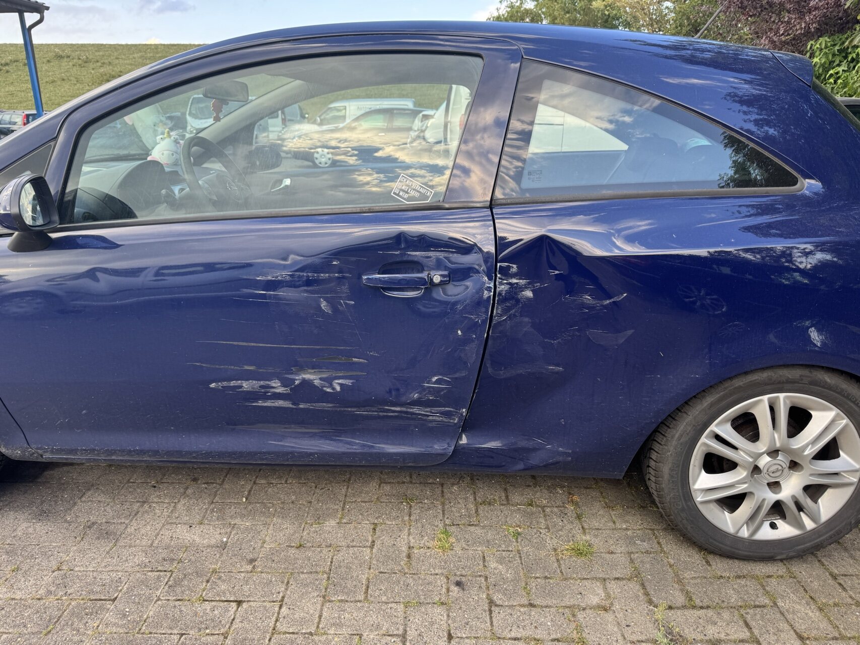 Großflächiger Seitenaufprallschaden an einem blauen Pkw